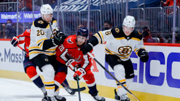 WASHINGTON, DC - MAY 15: Lars Eller #20 of the Washington Capitals chases the puck between Curtis Lazar #20 and Mike Reilly #6 of the Boston Bruins during the second period during Game One of the First Round of the 2021 Stanley Cup Playoffs May 15, 2021 at Capital One Arena on May 15, 2021 in Washington, DC. (Photo by Tim Nwachukwu/Getty Images)