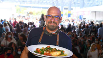 NEW YORK, NEW YORK - OCTOBER 16: Chef Michael Symon holds a cooking demonstration during the Grand Tasting featuring culinary demonstrations presented by Liebherr Appliances during the Food Network & Cooking Channel New York City Wine & Food Festival presented by Capital One at Pier 76 on October 16, 2021 in New York City. (Photo by Dave Kotinsky/Getty Images for NYCWFF)
