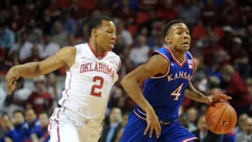 Mar 7, 2015; Norman, OK, USA; Kansas Jayhawks guard Devonte Graham (4) brings the ball up the court against Oklahoma Sooners guard Dinjiyl Walker (2) during the first half at Lloyd Noble Center. Mandatory Credit: Mark D. Smith-USA TODAY Sports