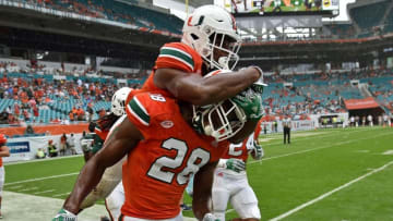 Nov 5, 2016; Miami Gardens, FL, USA; Miami Hurricanes running back Mark Walton (left) celebrates with Hurricanes running back Crispian Atkins (right) during the second half against Pittsburgh Panthers at Hard Rock Stadium. Mandatory Credit: Steve Mitchell-USA TODAY Sports