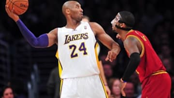 January 13, 2013; Los Angeles, CA, USA; Los Angeles Lakers shooting guard Kobe Bryant (24) controls the ball against the defense of Cleveland Cavaliers point guard Kyrie Irving (2) during the first half at Staples Center. Mandatory Credit: Gary A. Vasquez-USA TODAY Sports
