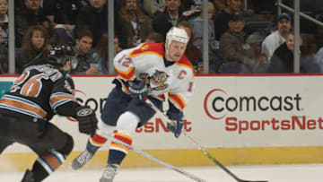 WASHINGTON - FEBRUARY 7: Center Olli Jokinen #12 of the Florida Panthers looks to make a pass around defenseman Shaone Morrisonn #26 of the Washington Capitals during their NHL game on February 7, 2006 at MCI Center in Washington, DC. The Panthers won 5-0. (Photo by Mitchell Layton/Getty Images)
