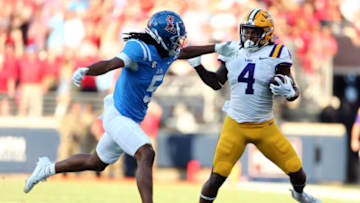 Sep 30, 2023; Oxford, Mississippi, USA; LSU Tigers running back John Emery Jr. (4) runs with the ball as Mississippi Rebels defensive back John Saunders Jr. (5) attempts to make the tackle during the first quarter at Vaught-Hemingway Stadium. Mandatory Credit: Petre Thomas-USA TODAY Sports