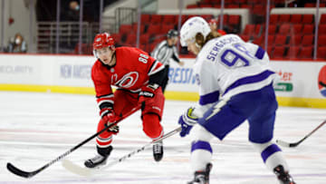 RALEIGH, NORTH CAROLINA - FEBRUARY 22: Martin Necas #88 of the Carolina Hurricanes and Mikhail Sergachev #98 of the Tampa Bay Lightning work to control the puck during the first period of their game at PNC Arena on February 22, 2021 in Raleigh, North Carolina. (Photo by Jared C. Tilton/Getty Images)