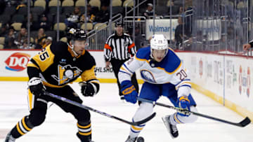 Oct 7, 2022; Pittsburgh, Pennsylvania, USA; Pittsburgh Penguins center Ryan Poehling (25) and Buffalo Sabres defenseman Lawrence Pilut (20) chase the puck during the third period at PPG Paints Arena. The Penguins won 7-1. Mandatory Credit: Charles LeClaire-USA TODAY Sports