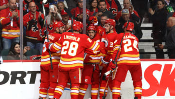 CALGARY, ALBERTA - OCTOBER 05: Sean Monahan #23, Johnny Gaudreau #13 and teammates of the Calgary Flames celebrate a goal against the Vancouver Canucks at Scotiabank Saddledome on October 05, 2019 in Calgary, Canada. (Photo by Gerry Thomas/NHLI via Getty Images)