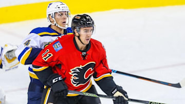 Oct 13, 2015; Calgary, Alberta, CAN; Calgary Flames center Mikael Backlund (11) and St. Louis Blues defenseman Carl Gunnarsson (4) fight for position during the third period at Scotiabank Saddledome. St. Louis Blues won 4-3. Mandatory Credit: Sergei Belski-USA TODAY Sports
