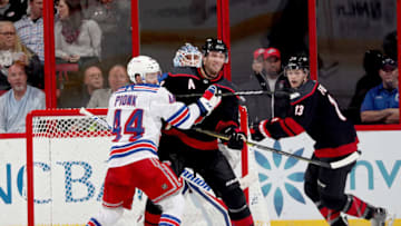 RALEIGH, NC - OCTOBER 07: Jordan Staal #11 of the Carolina Hurricanes battles for position in the crease with Neal Pionk #44 of the New York Rangers during an NHL game on October 7, 2018 at PNC Arena in Raleigh, North Carolina. (Photo by Gregg Forwerck/NHLI via Getty Images)