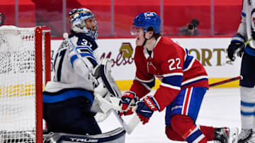 Apr 30, 2021; Montreal, Quebec, CAN; Montreal Canadiens forward Cole Caufield (22) reacts after teammate Montreal Canadiens forward Artturi Lehkonen (62) (not pictured) scores a goal against Winnipeg Jets goalie Connor Hellebuyck (37) during the second period at the Bell Centre. Mandatory Credit: Eric Bolte-USA TODAY Sports