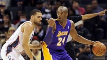 Dec 14, 2013; Charlotte, NC, USA; Los Angeles Lakers guard Kobe Bryant (24) looks to pass as he is defended by Charlotte Bobcats forward Jeffery Taylor (44) during the second half of the game at Time Warner Cable Arena. Lakers win 88-85. Mandatory Credit: Sam Sharpe-USA TODAY Sports
