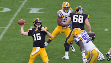 TAMPA, FL - JANUARY 1: Quarterback Jake Ruddock #15 of the Iowa Hawkeyes passes in the first quarter under pressure from Anthony Johnson #90 of the LSU Tigers January 1, 2014 in the Outback Bowl at Raymond James Stadium in Tampa, Florida. LSU won 21-14. (Photo by Al Messerschmidt/Getty Images)