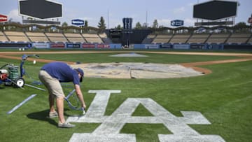LOS ANGELES, CA - MARCH 27: Grounds crewmen paint the LA logo on the field behind home plate at Dodger Stadium on March 27, 2019 in Los Angeles, California. (Photo by John McCoy/Getty Images)