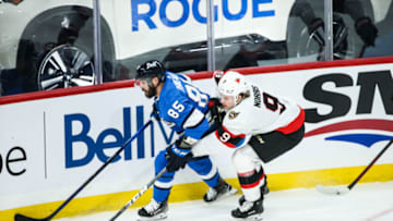 Feb 13, 2021; Winnipeg, Manitoba, CAN; Winnipeg Jets forward Matthieu Perreault (85) tries to skates away from Ottawa Senators forward Josh Norris (9) during the third period at Bell MTS Place. Mandatory Credit: Terrence Lee-USA TODAY Sports