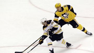 Apr 25, 2021; Pittsburgh, Pennsylvania, USA; Boston Bruins right wing David Pastrnak (88) skates the puck around Pittsburgh Penguins defenseman Brian Dumoulin (8) during the third period at PPG Paints Arena. The Penguins shutout the Bruins 1-0. Mandatory Credit: Charles LeClaire-USA TODAY Sports