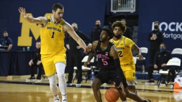 Dec 13, 2020; Ann Arbor, Michigan, USA; Penn State Nittany Lions guard Jamari Wheeler (5) dribbles the ball as Michigan Wolverines center Hunter Dickinson (1) and guard Mike Smith (12) defend during the second half at Crisler Center. Mandatory Credit: Tim Fuller-USA TODAY Sports
