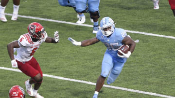Oct 24, 2020; Chapel Hill, North Carolina, USA; North Carolina Tar Heels running back Javonte Williams (25) runs for a touchdown as North Carolina State Wolfpack safety Jakeen Harris (6) defends in the fourth quarter at Kenan Memorial Stadium. Mandatory Credit: Bob Donnan-USA TODAY Sports