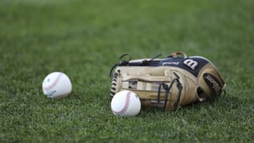 CLEVELAND, OH - AUGUST 24: A glove and baseballs sit on the field before a game between the Kansas City Royals and the Cleveland Indians at Progressive Field on August 24, 2019 in Cleveland, Ohio. Teams are wearing special color schemed uniforms with players choosing nicknames to display for Players' Weekend. (Photo by Ron Schwane/Getty Images)