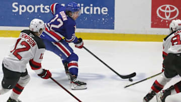 Rochester's Jack Quinn looks for room to move as Utica's Tyce Thompson (12), left, and Kevin Bahl (88), right, keep his boxed in during Game 4 of their North Division semifinal series Tuesday, May 17, 2022 at Blue Cross Arena. Utica won the game 4-2.Sd 051722 Amerks P Spts
