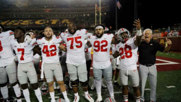 Ohio State Buckeyes Thayer Munford (75), Haskell Garrett (92), Miyan Williams (28) and defensive coordinator Kery Coombs sign Carmen Ohio after beating Minnesota Golden Gophers 45-31 in Huntington Bank Stadium at University of Minnesota in Minneapolis, MN on September 2, 2021.Ceb Osu21min Kwr 65