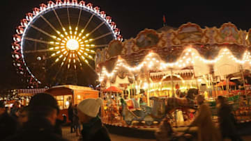 BERLIN, GERMANY - NOVEMBER 21: Visitors walk among a merry-go-round and a ferris wheel at the annual Christmas market at Alexanderplatz on the market's opening day on November 21, 2016 in Berlin, Germany. Christmas markets are opening across Germany this week in a tradition that dates back centuries. For the next four weeks the Christmas markets, which are usually located on the main square of the hosting town or village, will provide holiday cheer with stalls selling mulled wine, sausages, Christmas ornaments and other delights. (Photo by Sean Gallup/Getty Images)
