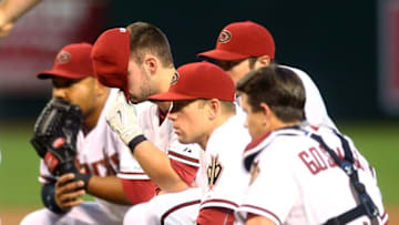Apr 28, 2015; Phoenix, AZ, USA; Arizona Diamondbacks shortstop Chris Owings covers his face with his hat as he reacts alongside teammates after pitcher Archie Bradley (not pictured) was hit in the face by a second inning line drive against the Colorado Rockies at Chase Field. Mandatory Credit: Mark J. Rebilas-USA TODAY Sports