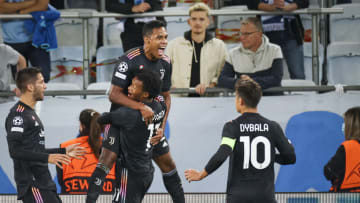 Juventus' Brazilian defender Alex Sandro (top) jumps on Juventus' Colombian midfielder Juan Cuadrado as he celebrates scoring the opening goal with his teammates during the UEFA Champions League group H football match Malmo FF vs Juventus F.C. in Malmo, Sweden on September 14, 2021. - - Sweden OUT (Photo by Anders Bjuro / various sources / AFP) / Sweden OUT (Photo by ANDERS BJURO/TT News Agency/AFP via Getty Images)