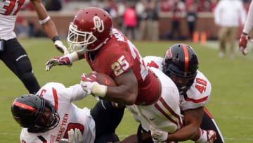 Oct 24, 2015; Norman, OK, USA; Oklahoma Sooners running back Joe Mixon (25) fights for yardage against Texas Tech Red Raiders defensive back J.J. Gaines (3) and Red Raiders linebacker Dakota Allen (40) during the third quarter at Gaylord Family - Oklahoma Memorial Stadium. Mandatory Credit: Mark D. Smith-USA TODAY Sports