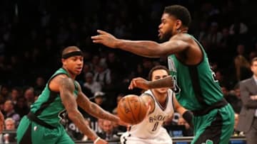 Jan 4, 2016; Brooklyn, NY, USA; Brooklyn Nets guard Shane Larkin (0) passes between Boston Celtics guard Isaiah Thomas (4) and forward Amir Johnson (90) during the first quarter at Barclays Center. Mandatory Credit: Anthony Gruppuso-USA TODAY Sports