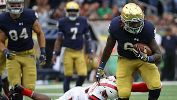 SOUTH BEND, IN - SEPTEMBER 08: Tony Jones Jr. #6 of the Notre Dame Fighting Irish breaks a tackle attempt by Brett Anderson II #23 of the Ball State Cardinals on his way to a 31 yard touchdown at Notre Dame Stadium on September 8, 2018 in South Bend, Indiana. (Photo by Jonathan Daniel/Getty Images)