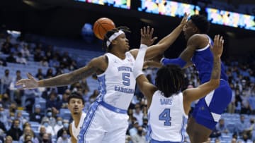 CHAPEL HILL, NORTH CAROLINA - NOVEMBER 23: Jamon Battle #1 of the UNC Asheville Bulldogs passes around Armando Bacot #5 and R.J. Davis #4 of the North Carolina Tar Heels during the first half of their game at the Dean E. Smith Center on November 23, 2021 in Chapel Hill, North Carolina. (Photo by Grant Halverson/Getty Images)