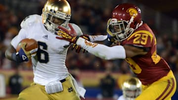LOS ANGELES, CA - NOVEMBER 24: Theo Riddick #6 of the Notre Dame Fighting Irish gives Jawanza Starling #29 of the USC Trojans a stiff arm as he carries the ball during a 22-13 Notre Dame win at Los Angeles Memorial Coliseum on November 24, 2012 in Los Angeles, California. (Photo by Harry How/Getty Images)