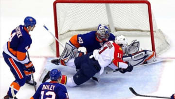 Apr 16, 2013; Uniondale, NY, USA; Florida Panthers center Jonathan Huberdeau (11) takes a shot on New York Islanders goalie Evgeni Nabokov (20) in front of New York Islanders defenseman Radek Martinek (4) and New York Islanders center Josh Bailey (12) period of an NHL game at the Nassau Veterans Memorial Coliseum. Mandatory Credit: Brad Penner-USA TODAY Sports