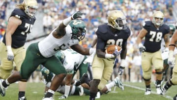 SOUTH BEND, IN - SEPTEMBER 3: Cierre Wood #20 of the Notre Dame Fighting Irish tries to outrun the pursuit by Julius Forte #54 of the South Florida Bulls at Notre Dame Stadium on September 3, 2011 in South Bend, Indiana. South Florida won 23-20. (Photo by Joe Robbins/Getty Images)