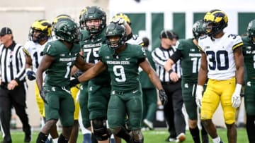 Michigan State's Kenneth Walker III, center, celebrates his touchdown with teammates, from left, Jayden Reed and Kevin Jarvis as Michigan's Daxton Hill, far right, looks on during the second quarter on Saturday, Oct. 30, 2021, at Spartan Stadium in East Lansing.211030 Msu Michigan 089a