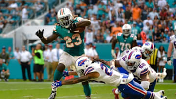 Oct 23, 2016; Miami Gardens, FL, USA; Miami Dolphins running back Jay Ajayi (23) carries the ball past Buffalo Bills inside linebacker Preston Brown (52) and Buffalo Bills cornerback Ronald Darby (28) during the second half at Hard Rock Stadium. The Dolphins won 28-25. Mandatory Credit: Steve Mitchell-USA TODAY Sports