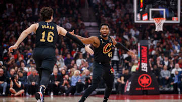 TORONTO, ON - OCTOBER 19: Donovan Mitchell #45 and Cedi Osman #16 of the Cleveland Cavaliers celebrate a basket during the first half against the Toronto Raptors at Scotiabank Arena on October 19, 2022 in Toronto, Canada. NOTE TO USER: User expressly acknowledges and agrees that, by downloading and or using this photograph, User is consenting to the terms and conditions of the Getty Images License Agreement. (Photo by Cole Burston/Getty Images)