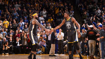 OAKLAND, CA - FEBRUARY 12: Demarcus Cousins #0 hi-fives Kevin Durant #35 of the Golden State Warriors on February 12, 2019 at ORACLE Arena in Oakland, California. NOTE TO USER: User expressly acknowledges and agrees that, by downloading and or using this photograph, user is consenting to the terms and conditions of Getty Images License Agreement. Mandatory Copyright Notice: Copyright 2019 NBAE (Photo by Noah Graham/NBAE via Getty Images)