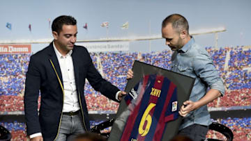Barcelona's midfielder Andres Iniesta (R) gives midfielder Xavi Hernandez a signed jersey during FC Barcelona's tribute to Xavi ahead of the Champions league final match in Berlin, his last match as Barcelona's player, at the Camp Nou stadium in Barcelona on June 3, 2015. AFP PHOTO / JOSEP LAGO (Photo credit should read JOSEP LAGO/AFP via Getty Images)