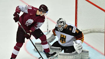Latvia's Rodrigo Abols (L) challenges for the puck with Germany's goalkeeper Niklas Treutle during the group B match Latvia vs Germany of the 2018 IIHF Ice Hockey World Championship at the Jyske Bank Boxen in Herning, Denmark, on May 12, 2018. (Photo by JOE KLAMAR / AFP) (Photo credit should read JOE KLAMAR/AFP/Getty Images)