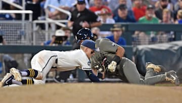 OMAHA, NE - JUNE 24: Blake Nelson #10 of the Michigan Wolverines tags out Austin Martin #16 of the Vanderbilt Commodores in the eighth inning during game one of the College World Series Championship Series on June 24, 2019 at TD Ameritrade Park Omaha in Omaha, Nebraska. (Photo by Peter Aiken/Getty Images)