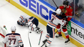 EDMONTON, ALBERTA - AUGUST 05: Tyler Ennis #63 of the Edmonton Oilers is injured in a collision with Kirby Dach #77 of the Chicago Blackhawks during the second period in Game Three of the Western Conference Qualification Round prior to the 2020 NHL Stanley Cup Playoffs at Rogers Place on August 05, 2020 in Edmonton, Alberta. (Photo by Jeff Vinnick/Getty Images)