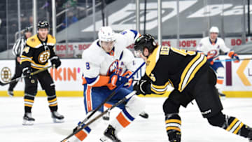 May 10, 2021; Boston, Massachusetts, USA; Boston Bruins defenseman Mike Reilly (6) pokes the puck away from New York Islanders defenseman Noah Dobson (8) during the third period at TD Garden. Mandatory Credit: Bob DeChiara-USA TODAY Sports