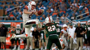 MIAMI GARDENS, FL - OCTOBER 21: Eric Dungey #2 of the Syracuse Orange tries to jump over Sheldrick Redwine #22 of the Miami Hurricanes during a game at Sun Life Stadium on October 21, 2017 in Miami Gardens, Florida. (Photo by Mike Ehrmann/Getty Images)