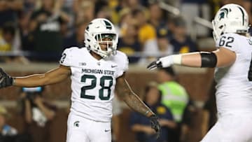 ANN ARBOR, MI - OCTOBER 07: Madre London #28 of the Michigan State Spartans celebrates after scoring with teammate Luke Campbell #62 during the second quarter of the game against the Michigan Wolverines at Michigan Stadium on October 7, 2017 in Ann Arbor, Michigan. (Photo by Leon Halip/Getty Images)