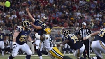 Aug 16, 2014; St. Louis, MO, USA; St. Louis Rams quarterback Sam Bradford (8) is hit by Green Bay Packers defensive end Julius Peppers (56) while attempting a pass during the first half at Edward Jones Dome. Mandatory Credit: Jasen Vinlove-USA TODAY Sports