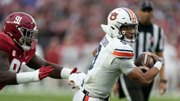 Auburn footballNov 26, 2022; Tuscaloosa, Alabama, USA; Auburn Tigers quarterback Robby Ashford (9) carries the ball against Alabama Crimson Tide defensive lineman Jaheim Oatis (91) at Bryant-Denny Stadium. Mandatory Credit: Marvin Gentry-USA TODAY Sports