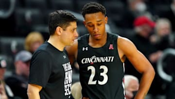 Cincinnati Bearcats head coach Wes Miller talks with guard Mika Adams-Woods. The Enquirer.