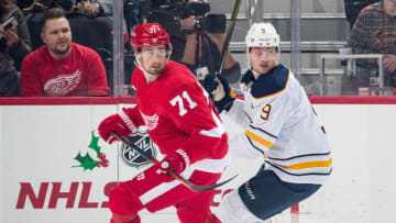 DETROIT, MI - NOVEMBER 24: Dylan Larkin #71 of the Detroit Red Wings skates along the boards followed by Jack Eichel #9 of the Buffalo Sabres during an NHL game at Little Caesars Arena on November 24, 2018 in Detroit, Michigan. (Photo by Dave Reginek/NHLI via Getty Images)