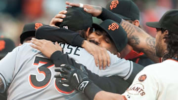 May 7, 2015; San Francisco, CA, USA; San Francisco Giants relief pitcher Sergio Romo (center) hugs Miami Marlins first baseman Michael Morse (38) after Morse received his 2014 World Series ring at AT&T Park. Mandatory Credit: Ed Szczepanski-USA TODAY Sports