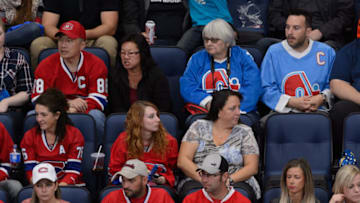 QUEBEC CITY, QC - SEPTEMBER 28: A pair of Quebec Nordiques supporters sit amongst a group of Montreal Canadiens fans during the NHL pre-season game between the Montreal Canadiens and the Pittsburgh Penguins at the Videotron Centre on September 28, 2015 in Quebec City, Quebec, Canada. The Montreal Canadiens defeated the Pittsburgh Penguins 4-1. (Photo by Minas Panagiotakis/Getty Images)